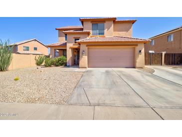 Two-story home featuring a spacious driveway and low-maintenance landscaping under a clear blue sky at 1556 E Gabrilla Dr, Casa Grande, AZ 85122