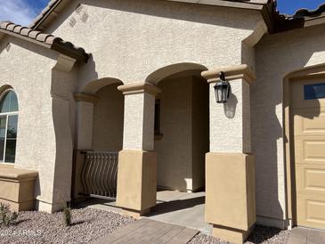 Charming front porch with an arched entrance and a view of the meticulously landscaped yard at 15801 W Cielo Grande Ave, Surprise, AZ 85387