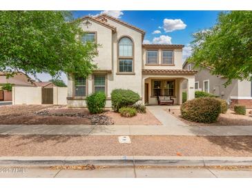 Charming two-story home with landscaped yard, covered porch, and appealing desert-toned exterior at 1912 S Colt Dr, Gilbert, AZ 85295