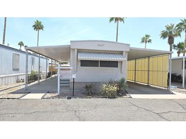 Charming mobile home featuring covered parking and well-maintained landscaping in a vibrant community at 345 S 58Th St # 10, Mesa, AZ 85206