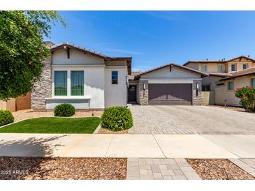 Beautiful single-story home featuring a two-car garage, paver driveway, manicured lawn, and stone facade accents at 3856 E Shannon St, Gilbert, AZ 85295