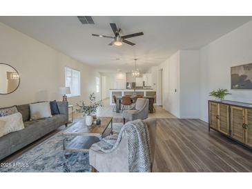 Spacious living room with ceiling fan flows into the dining area and kitchen at 5096 S 245Th Dr, Buckeye, AZ 85326