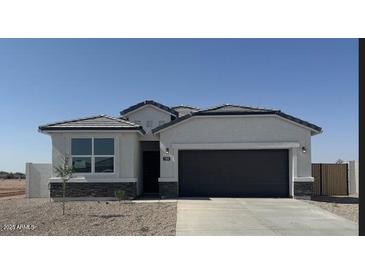 Charming single-story home featuring a gray two-car garage and modern architectural details against a clear blue sky at 1300 W Bealey Ave, Coolidge, AZ 85128