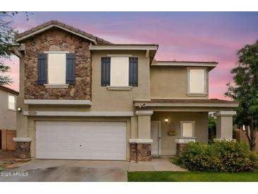Charming two-story home featuring a stone facade, well-manicured lawn and an attached two-car garage at 16139 N 171St Ln, Surprise, AZ 85388