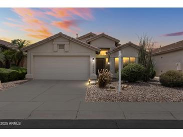 Charming single-story home with a two-car garage, neutral palette, and desert landscaping, set against a colorful sunset sky at 16424 S 46Th Way, Phoenix, AZ 85048