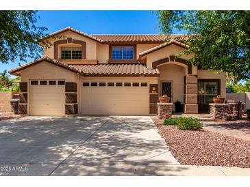 Inviting two-story home with a three-car garage and well-maintained desert landscaping at 2648 E Teakwood Pl, Chandler, AZ 85249
