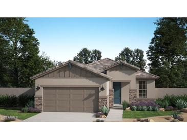 Charming single-story home featuring a two-car garage, stone accents, neutral paint, and professionally landscaped front yard at 3155 S 232Nd Ave, Buckeye, AZ 85326