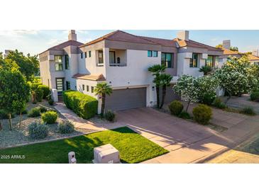 Beautiful townhome with a two-car garage, lush landscaping, and a well-maintained lawn at 7222 E Gainey Ranch Rd # 140, Scottsdale, AZ 85258