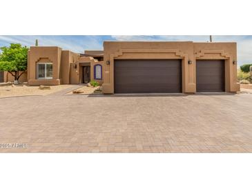 Stunning Southwestern-style home featuring a two-car garage and well-manicured desert landscaping at 8255 E Yearling Rd, Scottsdale, AZ 85255