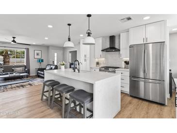 Bright kitchen with an island featuring barstool seating and stainless steel appliances at 8714 E Plaza Ave, Scottsdale, AZ 85250
