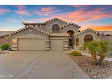 Elegant two-story home featuring a three-car garage and desert landscaping at 9702 E Naranja Ave, Mesa, AZ 85209
