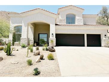 Charming single-Gathering home featuring a desert landscape, covered porch, and a spacious three-car garage at 11446 E Sweetwater Ave, Scottsdale, AZ 85259