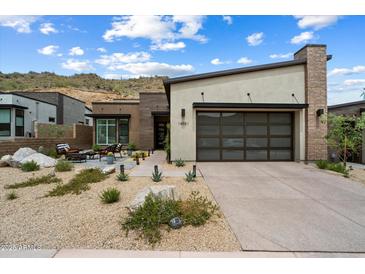 Charming single-story home featuring desert landscaping, a brick chimney, and a modern garage door at 14551 N Adero Canyon Dr, Fountain Hills, AZ 85268