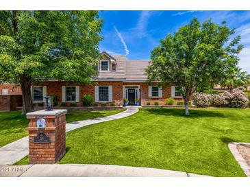 Charming brick home with well-maintained landscaping, lush green lawn, and a brick mailbox post at 198 N Pecan Ct, Gilbert, AZ 85234
