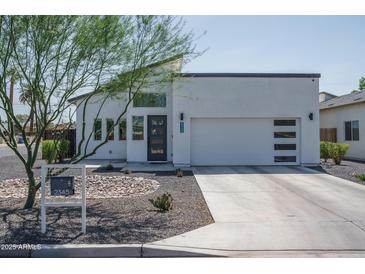 Modern home featuring clean lines, a well-manicured yard, and a two-car garage at 2345 N 28Th Pl, Phoenix, AZ 85008