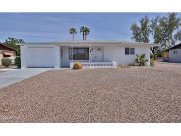 Charming single-story white home with a well-manicured yard and desert landscaping at 5510 E Dallas St, Mesa, AZ 85205