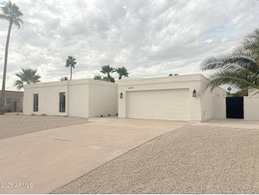 Contemporary white home with a two-car garage, desert landscaping, and a private courtyard at 6529 E Eugie Ter, Scottsdale, AZ 85254