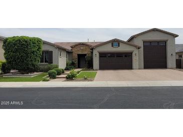Charming single-story home with a stone facade, well-manicured lawn, and a three-car garage at 9187 W Parkside Ln, Peoria, AZ 85383