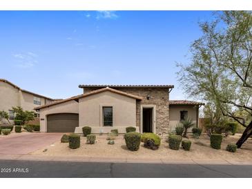 Charming single-story home featuring a stone facade, desert landscaping, and a welcoming entrance at 20055 N 96Th Way, Scottsdale, AZ 85255
