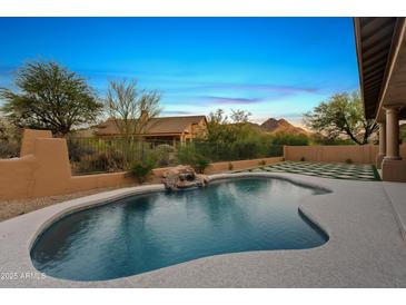 Beautiful pool with waterfall feature and mountain views, perfect for relaxing outdoors at 24645 N 117Th St, Scottsdale, AZ 85255