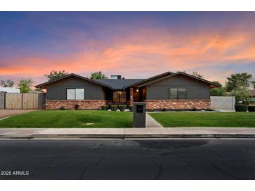 Charming single-story home with a brick accent, green lawn, and beautiful dusk sky at 2619 E Jerome Ave, Mesa, AZ 85204