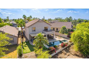 Aerial view of a home's backyard featuring a pool, spa, covered patio, putting green, and desert landscaping at 6847 S 27Th Pl, Phoenix, AZ 85042