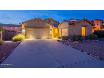 Charming single-story home with a well-lit driveway and attached three-car garage at 7606 E Globemallow Ln, Gold Canyon, AZ 85118