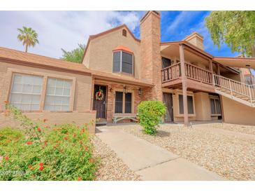 Charming townhome featuring a brick chimney, colorful landscaping, and a cozy, inviting entrance at 8111 W Wacker Rd # 62, Peoria, AZ 85381