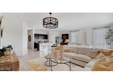 Bright, open-concept living room featuring a kitchen island with stool seating and stylish decor at 24052 W Pima St, Buckeye, AZ 85326
