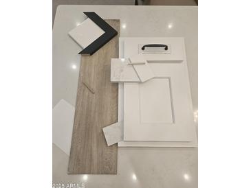 Selection of interior design finishes including flooring, cabinets, backsplash, and countertop samples at 2559 E Virginia Cir, Mesa, AZ 85213
