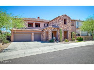 Two-story home featuring a three-car garage, stone accents, and a well-manicured front yard at 26703 N 90Th Dr, Peoria, AZ 85383