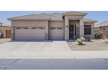 Charming single-story home featuring a well-manicured yard, neutral paint, and a three-car garage at 43319 W Oakland Ct, Maricopa, AZ 85138