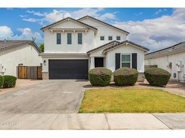 Charming two-story home featuring a dark garage door, well-manicured landscaping, and a welcoming facade at 512 E Bamboo Ln, San Tan Valley, AZ 85140