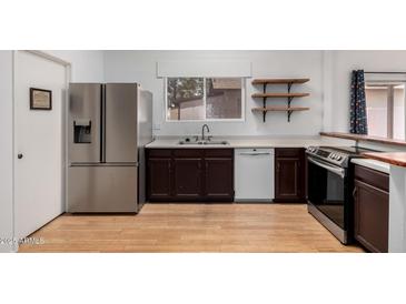 A spacious kitchen features stainless steel appliances, wooden floors, and custom shelves at 5135 E Evergreen St # 1166, Mesa, AZ 85205