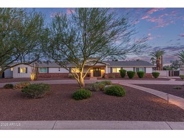 Charming single-story home featuring a well-manicured front yard and walkway under a picturesque sky at 6231 E Desert Cove Ave, Scottsdale, AZ 85254