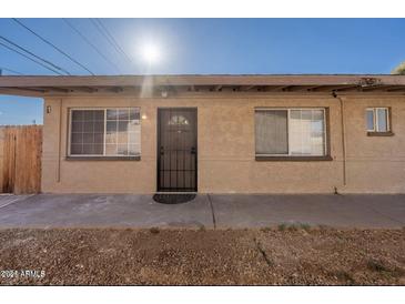 Tan apartment building with a security door, multiple windows, and a concrete walkway at 7101 N 36Th Ave # 102, Phoenix, AZ 85051