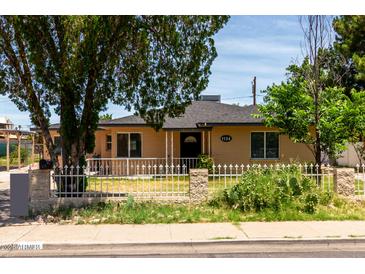 Charming single-story home featuring a tidy front yard with a white fence and mature landscaping at 1134 W 2Nd St, Mesa, AZ 85201
