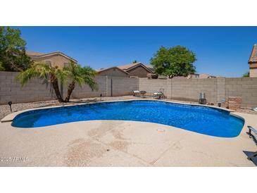 Sparkling blue pool surrounded by a patio and block wall for privacy at 12422 W Rosewood Dr, El Mirage, AZ 85335