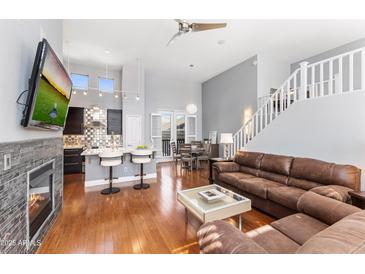 Open-concept living room with hardwood floors, a fireplace, and staircase with white railing at 15221 N Clubgate Dr # 2059, Scottsdale, AZ 85254
