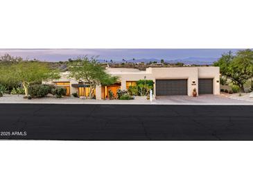 An exterior front view of a charming single-story home with a two-car garage and desert landscaping at 15816 E Eagle Crest Rd, Fountain Hills, AZ 85268