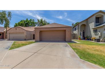Exterior view of the home featuring a large two-car garage and a well-manicured lawn at 1836 N Stapley Dr # 191, Mesa, AZ 85203