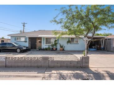 Charming single-story home with blue exterior, decorative rock yard and large covered carport at 8724 N 28Th Ave, Phoenix, AZ 85051