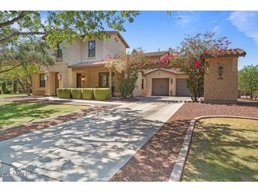 Charming home showcasing a well-manicured lawn, mature trees, and a welcoming entrance with a two-car garage at 20638 W Main St, Buckeye, AZ 85396