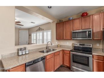 Charming kitchen with granite counters, stainless appliances, and convenient pass-through window at 40089 W Bonneau St, Maricopa, AZ 85138