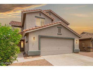 Charming home featuring a two-car garage, tiled roof, neutral stucco, and well-manicured landscaping at 41158 W Cahill Dr, Maricopa, AZ 85138