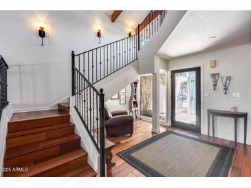 Inviting foyer featuring wood floors, a staircase with iron railings, and a view to the home's entrance at 4242 N 44Th St, Phoenix, AZ 85018