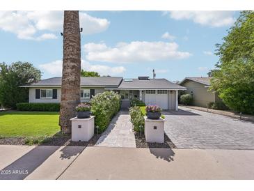 Charming single-story home featuring a well-manicured lawn and a brick driveway leading to an attached garage at 4320 N 35Th St, Phoenix, AZ 85018