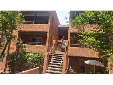 A charming exterior view shows the building's architecture with stairways and balconies at 4704 E Paradise Village N Pkwy # 211, Phoenix, AZ 85032