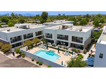 Aerial view showcases community pool, outdoor seating, landscaping, and modern building architecture at 1111 E Missouri Ave # 9, Phoenix, AZ 85014