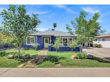 Charming blue home with a well-manicured front yard and inviting walkway at 1639 W Indianola Ave, Phoenix, AZ 85015